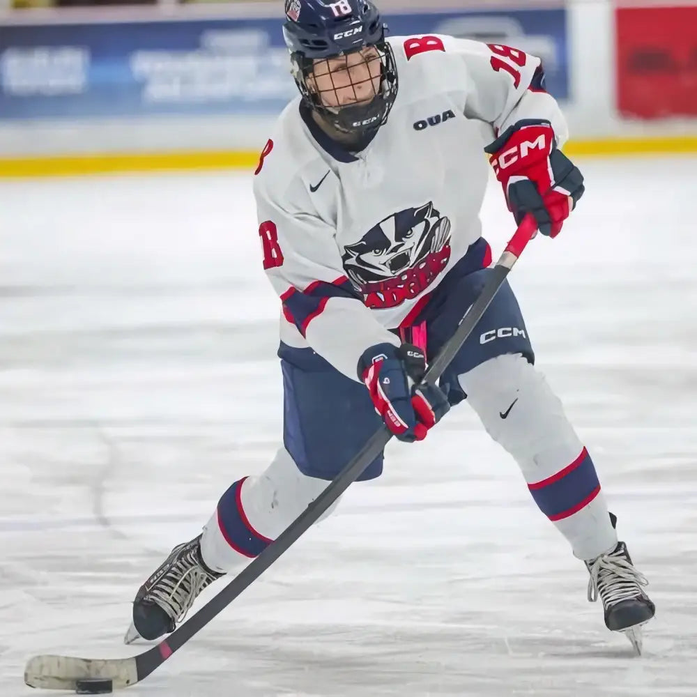 White and navy blue hockey jersey with red accents featuring black and white logo matching puig r-fighter fotpinne blå